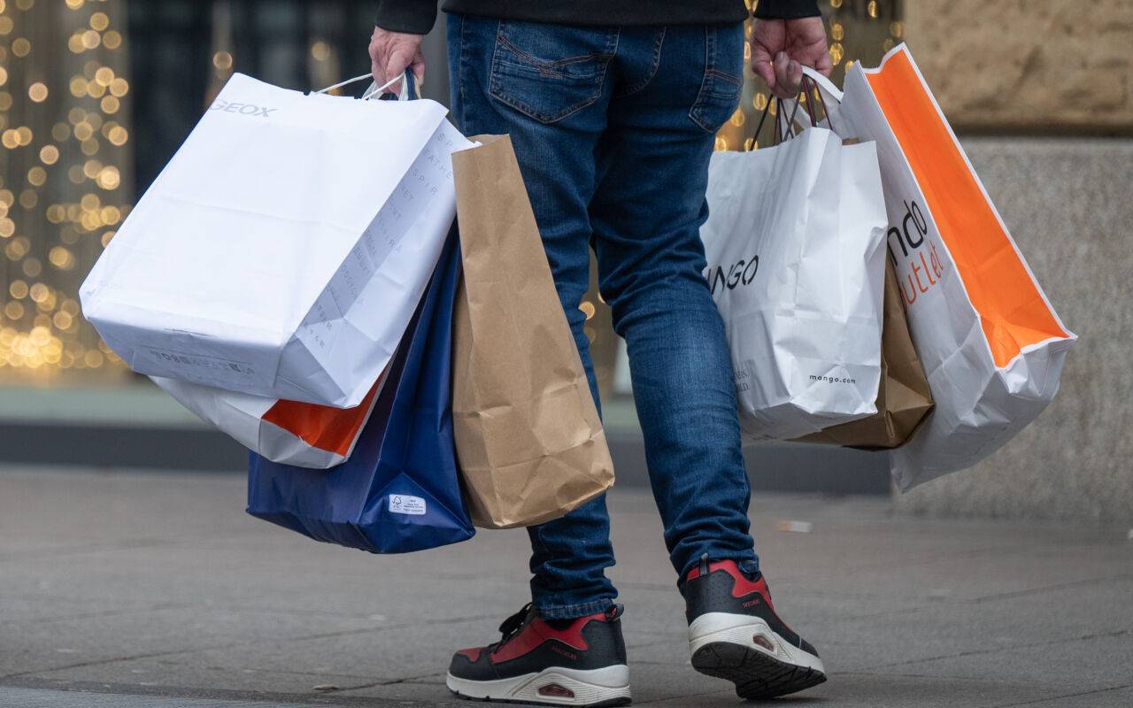 Ein Mann trägt viele Einkaufstaschen nach einer Shoppingtour