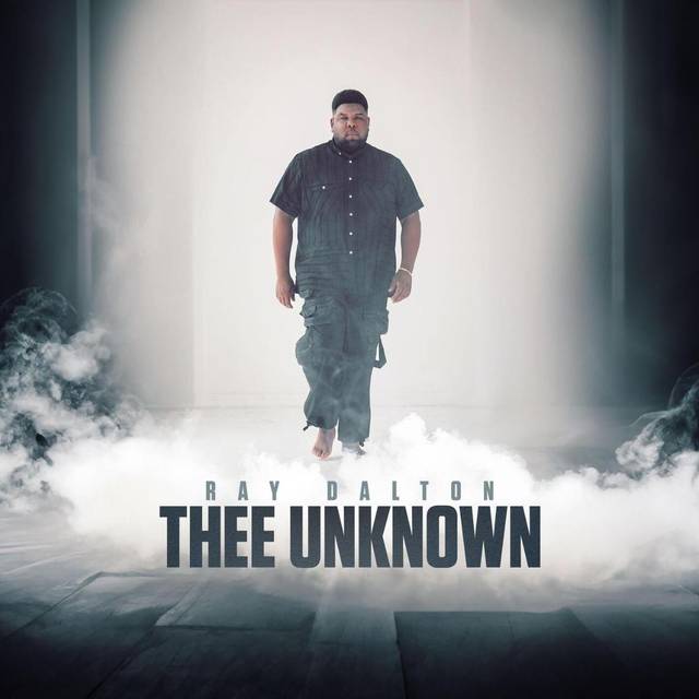 Das Musikcover der Single "Thee Unknown" von Ray Dalton zeigt ihn Barfuß in schwarzer Kleidung in einem weißen Raum mit Rauch.