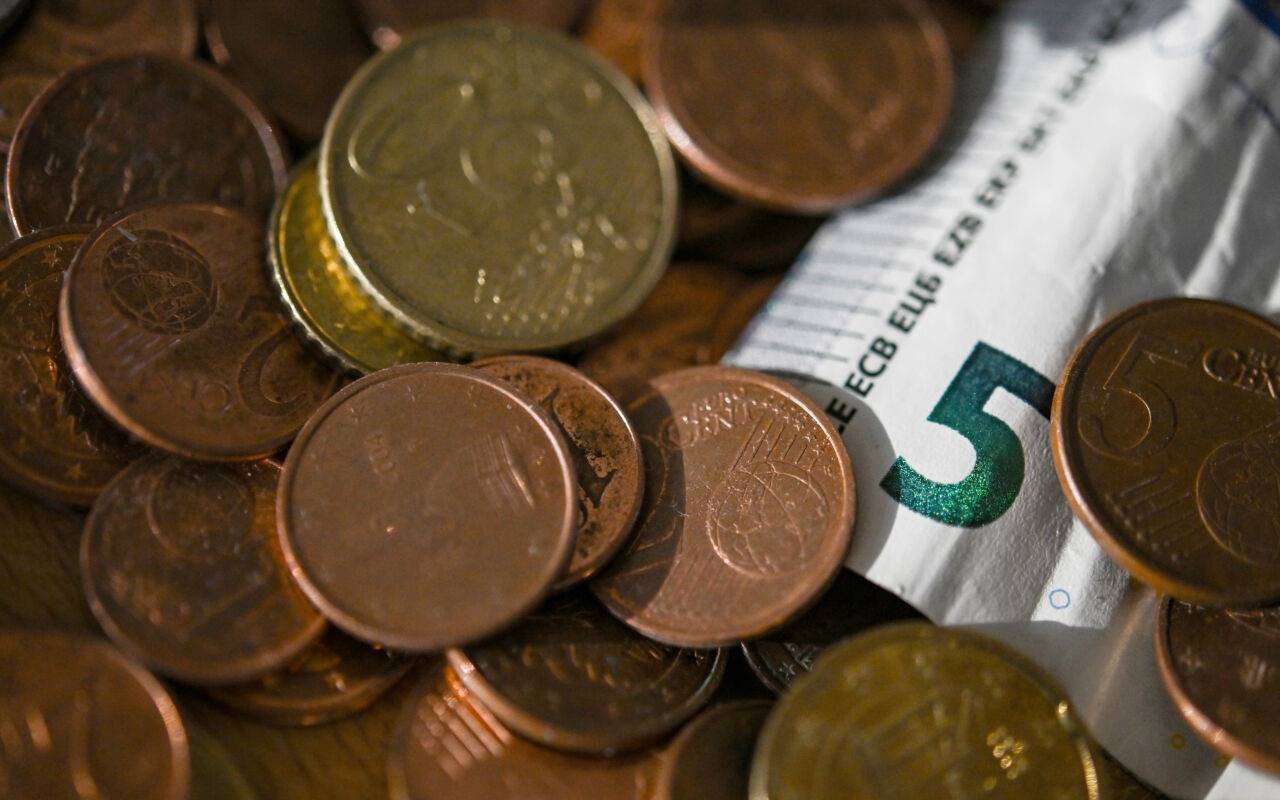 Geldmünzen und ein 5 Euro-Schein liegen in einer Schale. Das Statistische Bundesamt will die Inflationsrate für Oktober 2024 am 30.10.2024 bekannt geben.