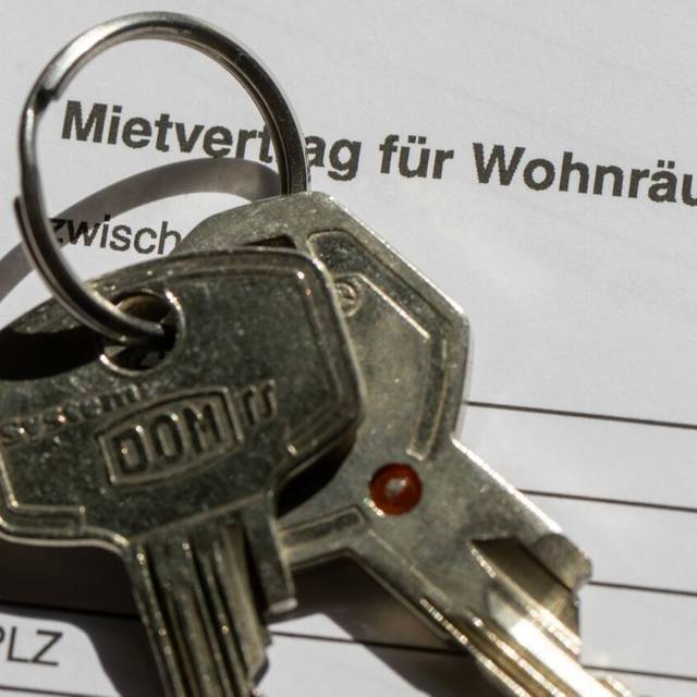 Ein Wohnungsschlüssel liegt auf einem Mietvertrag für eine Wohnung.