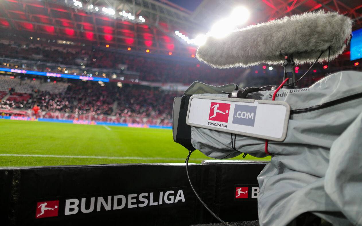 Eine Fernsehkamera ist am Spielfeldrand eines Bundesliga-Stadions zu sehen.