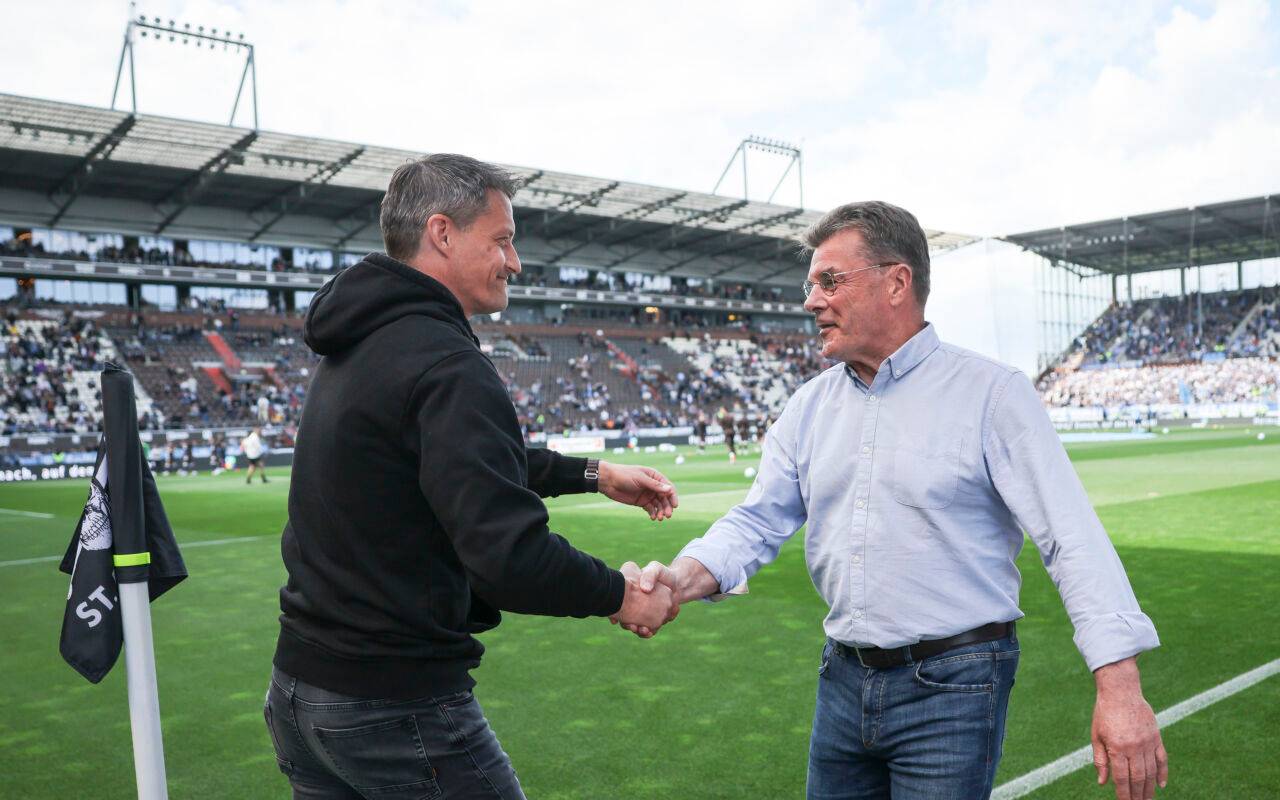 St. Paulis Trainer Alexander Blessin und Bochums Trainer Dieter Hecking (r) begrüßen sich vor dem Spiel mit einem Handschlag.