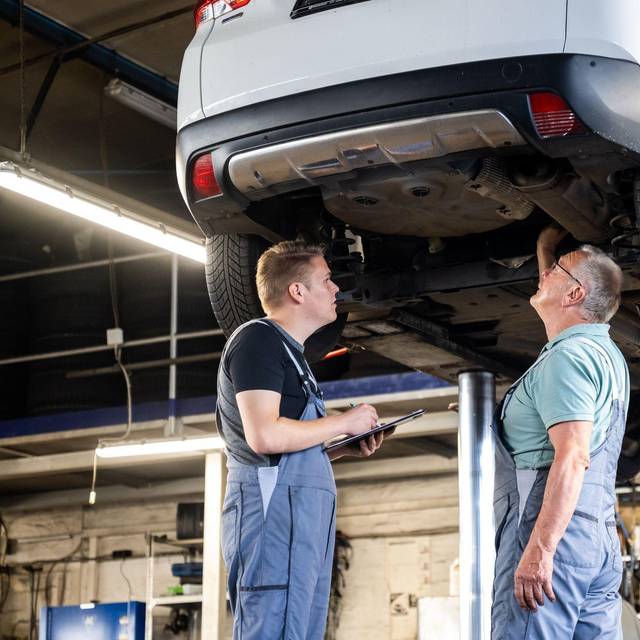 Zwei Männer arbeiten gemeinsam in einer Autowerkstatt