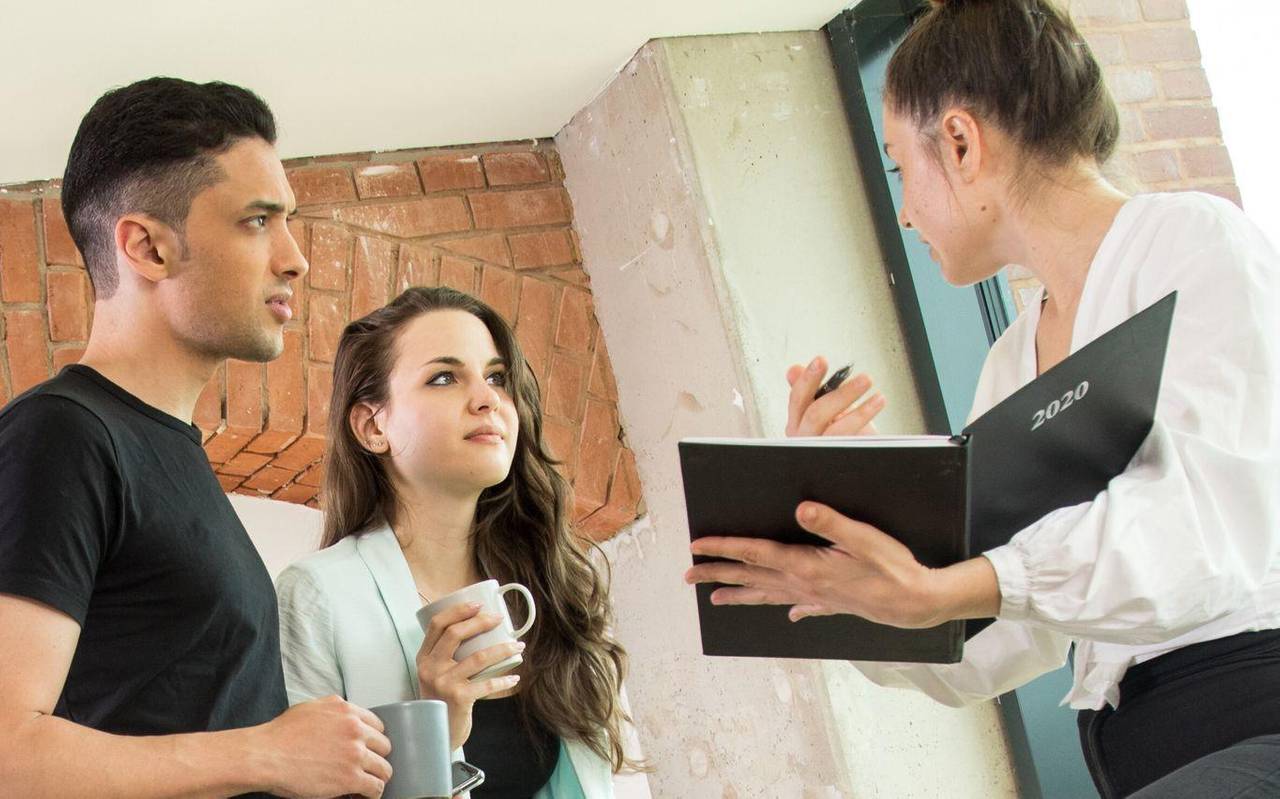 Drei Kollegen schauen in einen Terminplaner