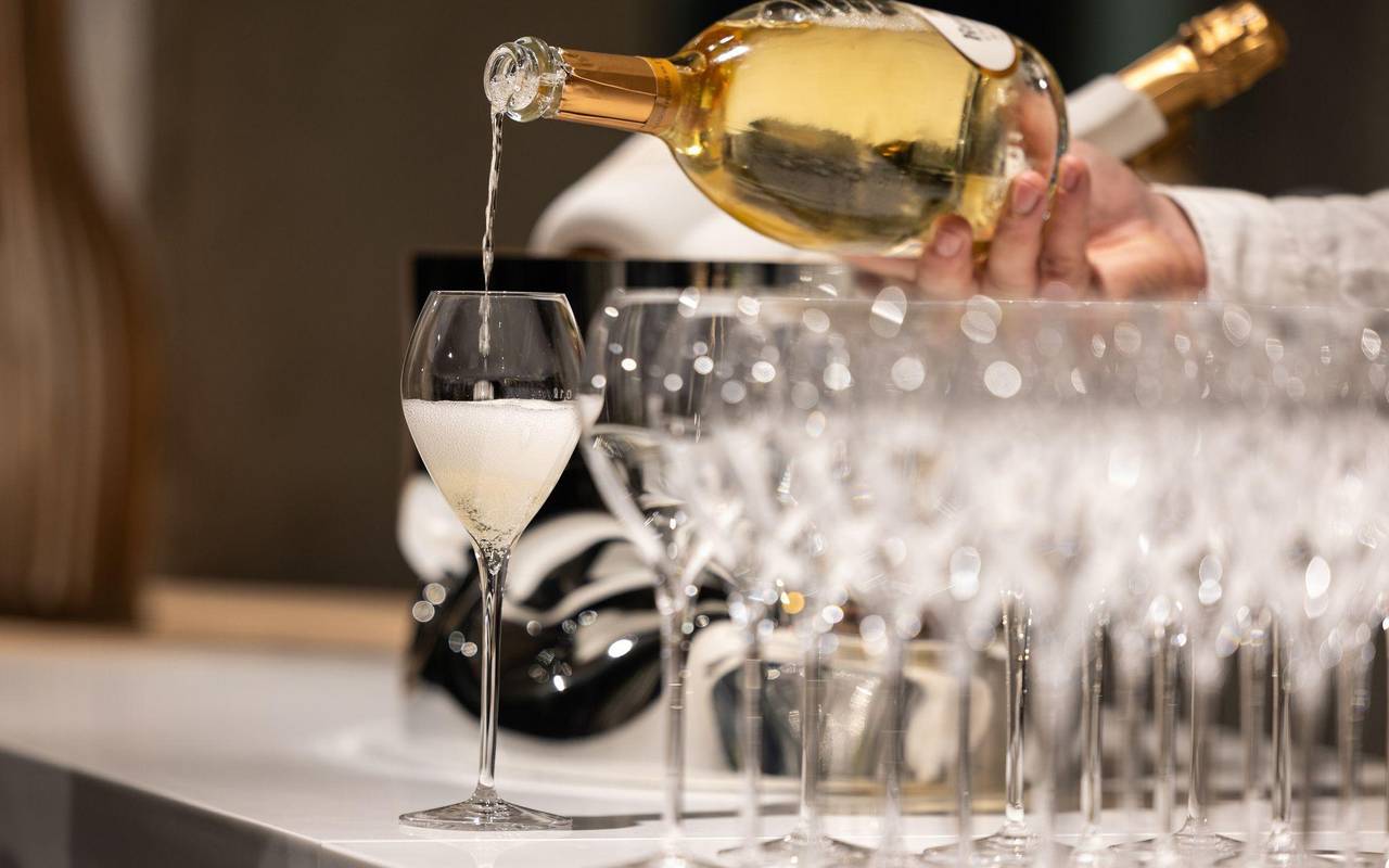 Kellner schenkt ein Glas Champagner ein