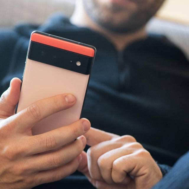 Ein Mann hält ein Google Pixel 6 in den Händen