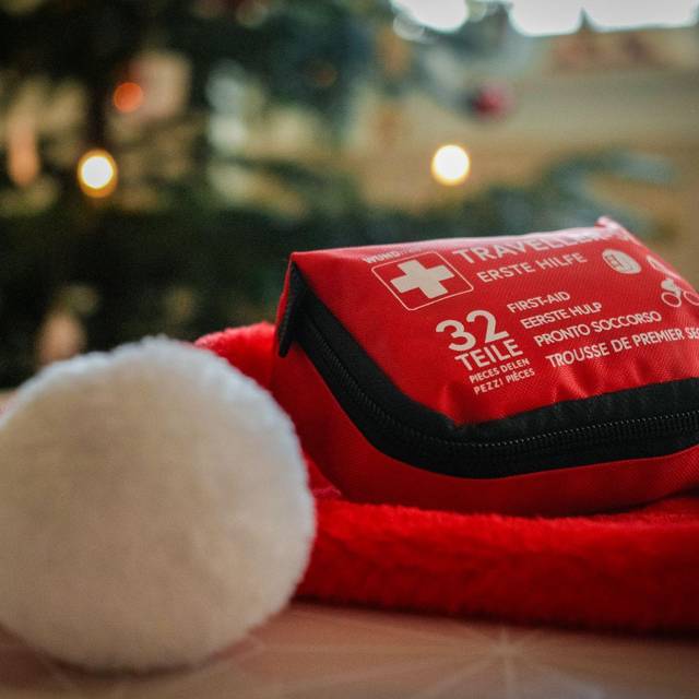 Ein Erste-Hilfe-Set liegt auf einer Weihnachtsmütze