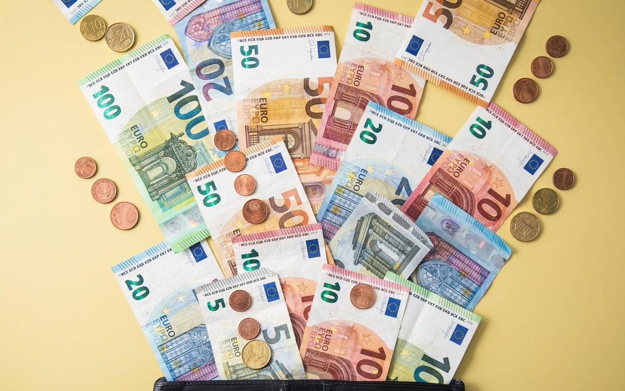 Geldscheine und Münzen fliegen aus einer Geldbörse