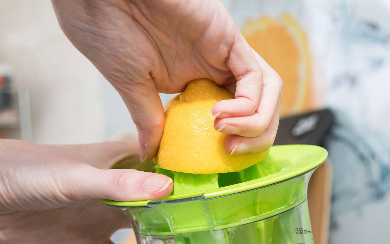 Eine Frau presst eine Zitrone aus
