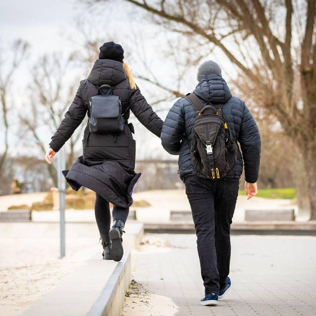 Spaziergänger durchqueren bei trübem Wetter einen Park