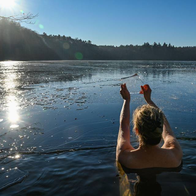 Frau geht in einem Loch im Eis baden