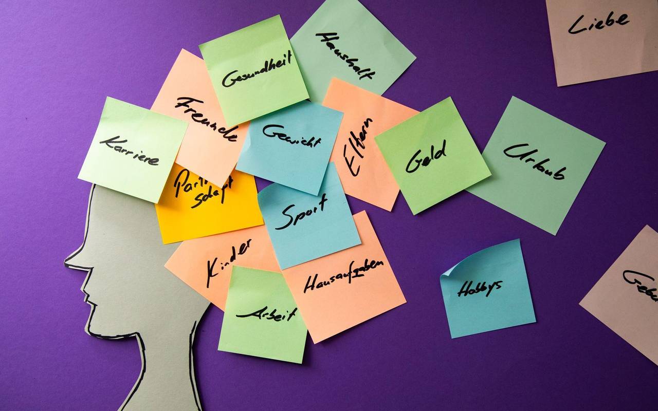 Eine Silhouette mit bunten Post-Its über dem Kopf