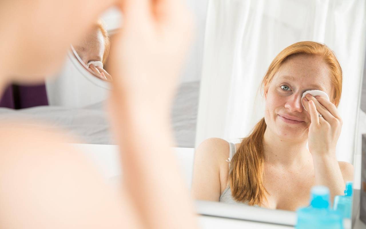 Eine Frau schminkt sich ab