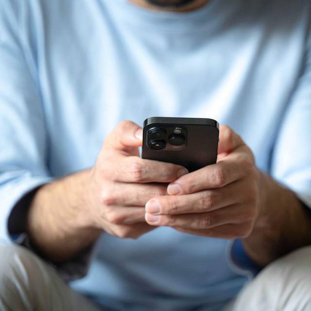 Ein Mann tippt auf einem Smartphone