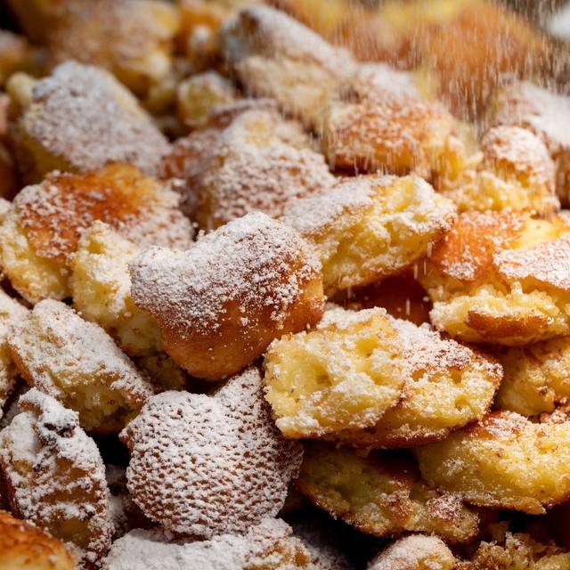 Kaiserschmarrn, der mit Puderzucker bestäubt wird