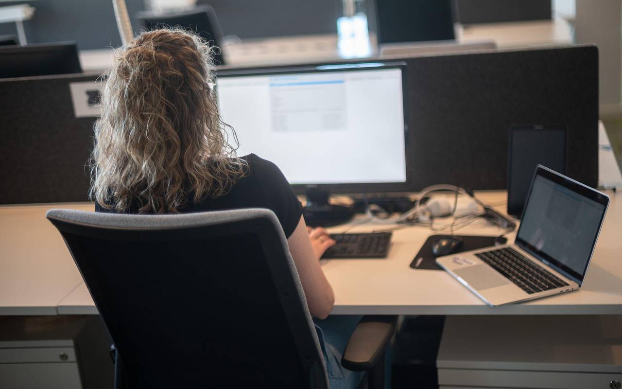 Eine Frau sitzt am Schreibtisch vor einem Bildschirm
