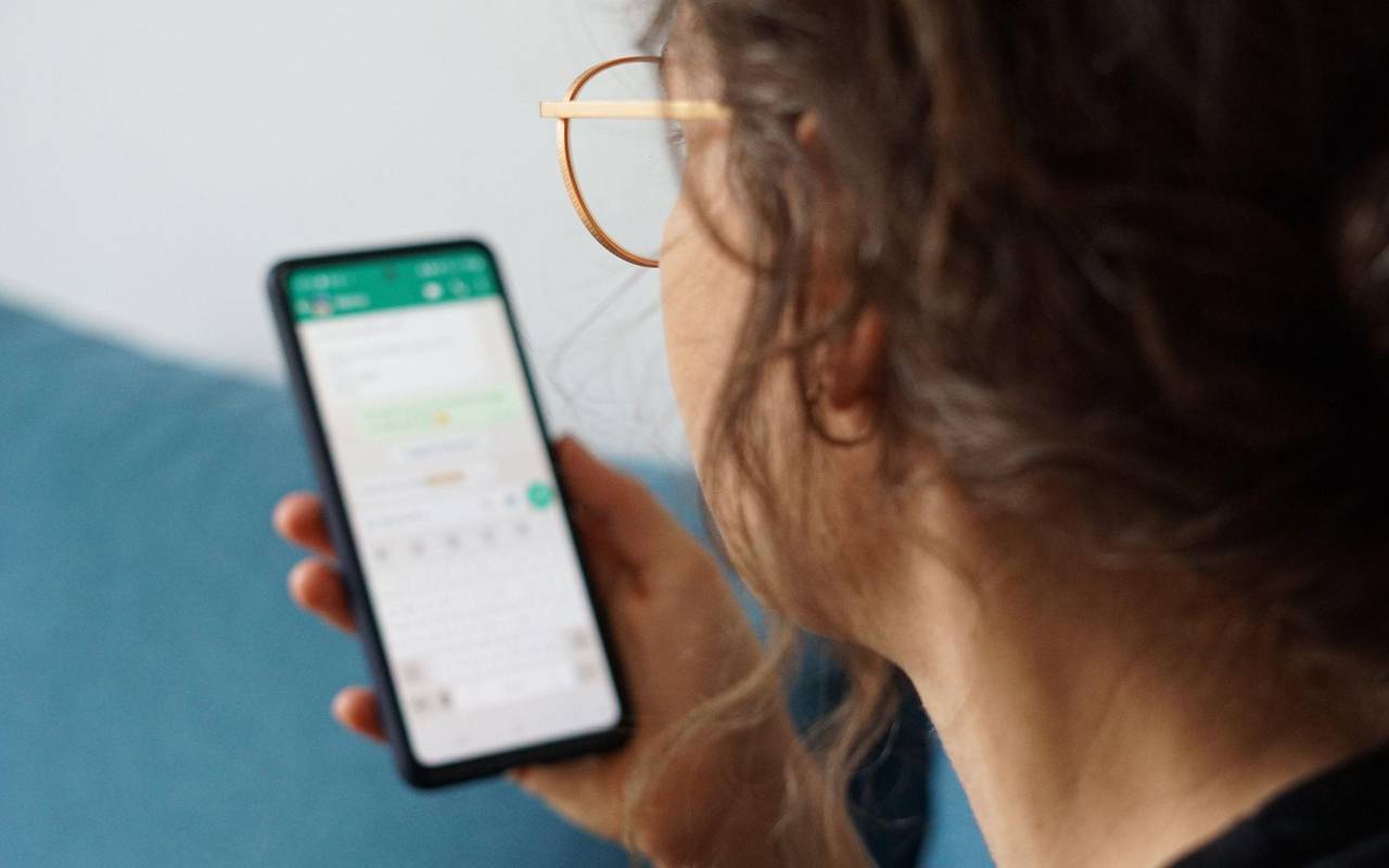 Eine junge Frau liest eine Nachricht auf einem Smartphone