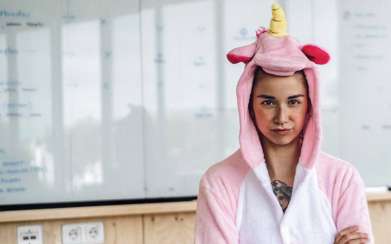 Frau trägt im Büro ein Einhorn-Kostüm