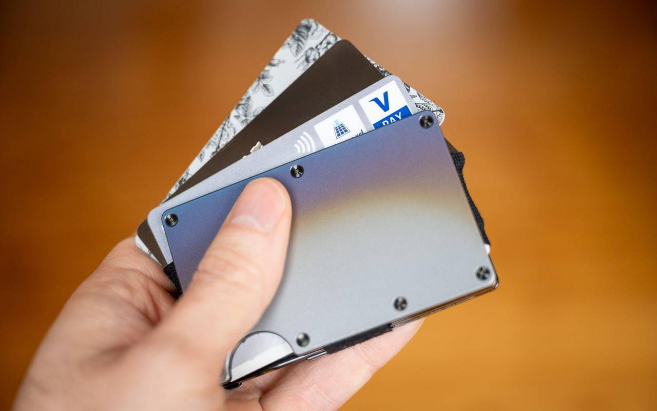 Ein Mann hält einen Cardholder mit verschiedenen Bezahlkarten
