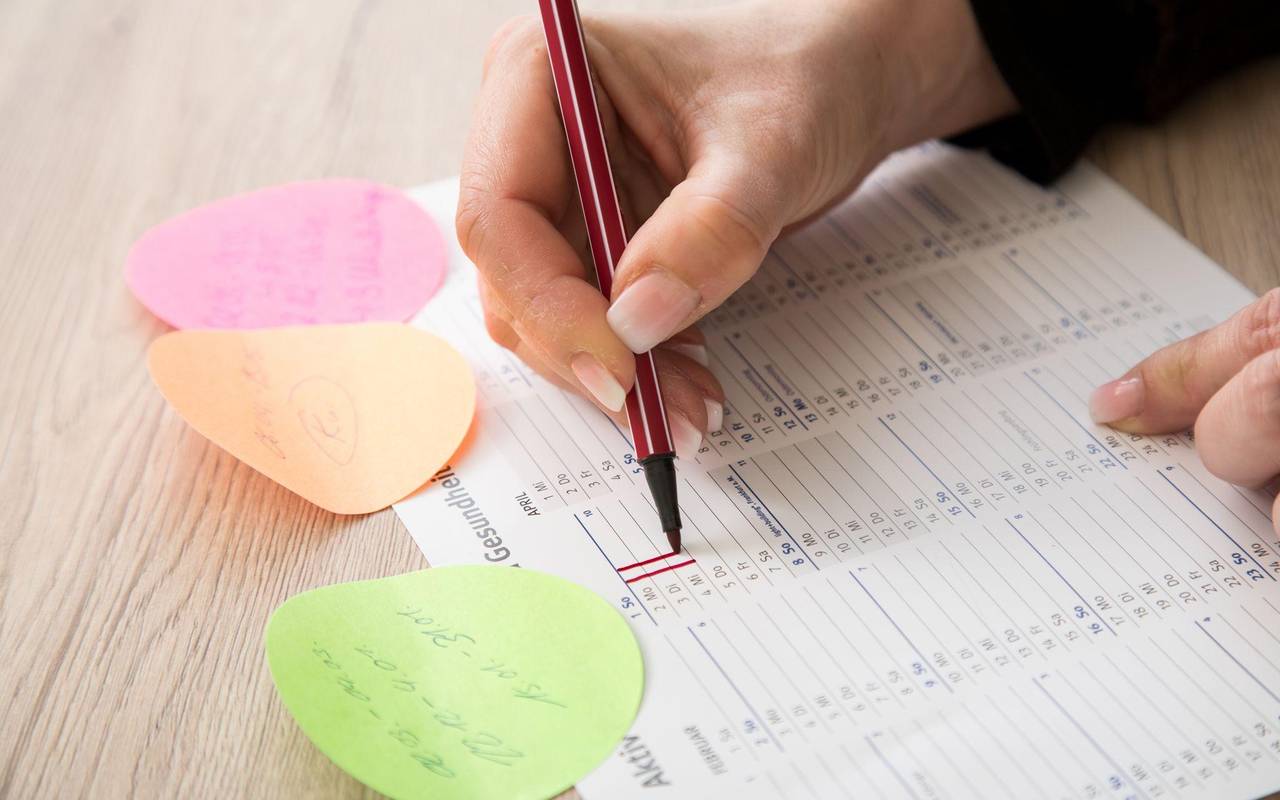 Eine Frau makiert Urlaubstage in einem Kalender