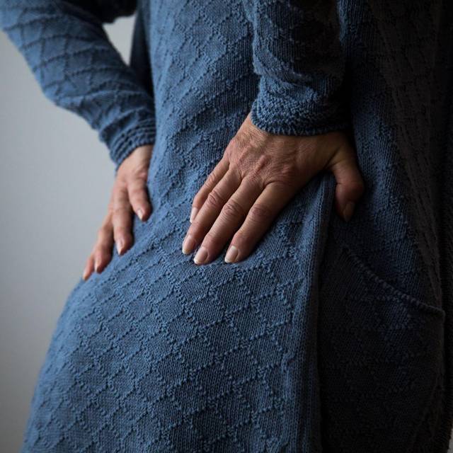 Frau hält sich den schmerzenden Rücken