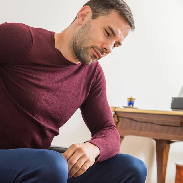 Ein Mann hält sich den unteren Rücken