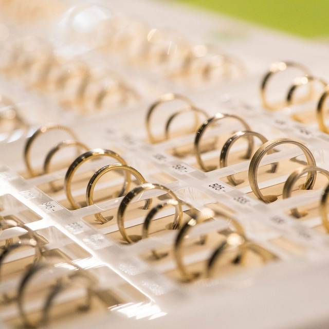 Eheringe liegen bei einer Hochzeitsmesse in einer Vitrine