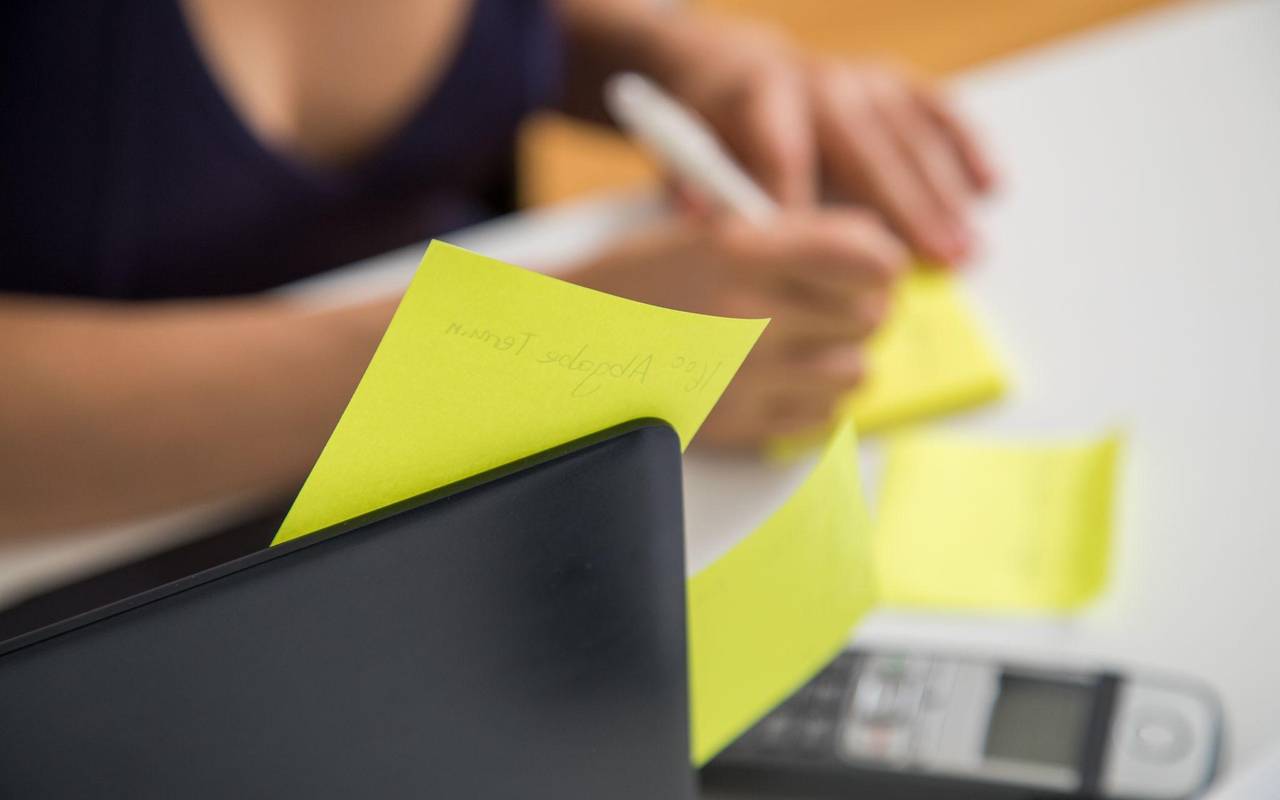 Eine Frau schreibt auf Klebezettel