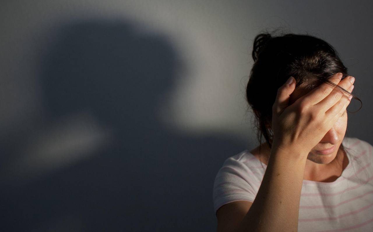 Frau fasst sich an die Stirn