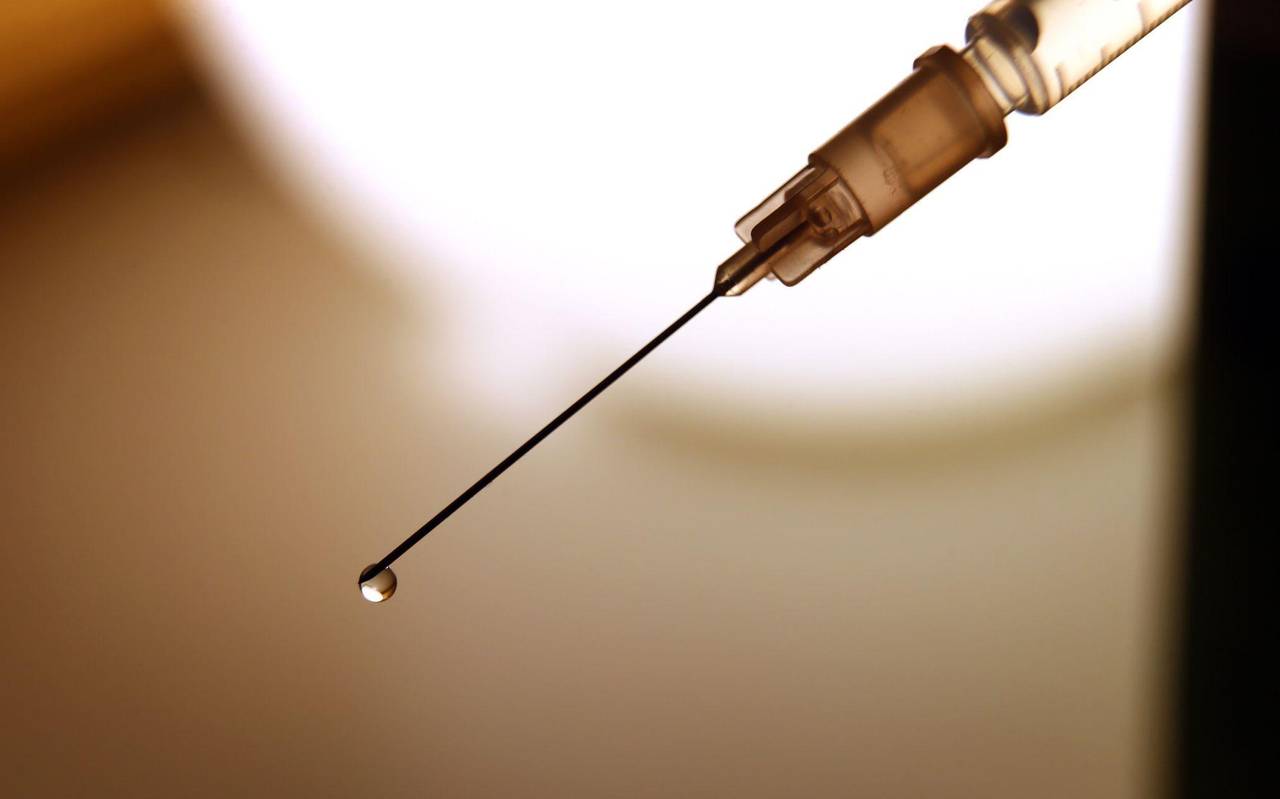Eine Flüssigkeit tropft aus der Kanüle einer Spritze