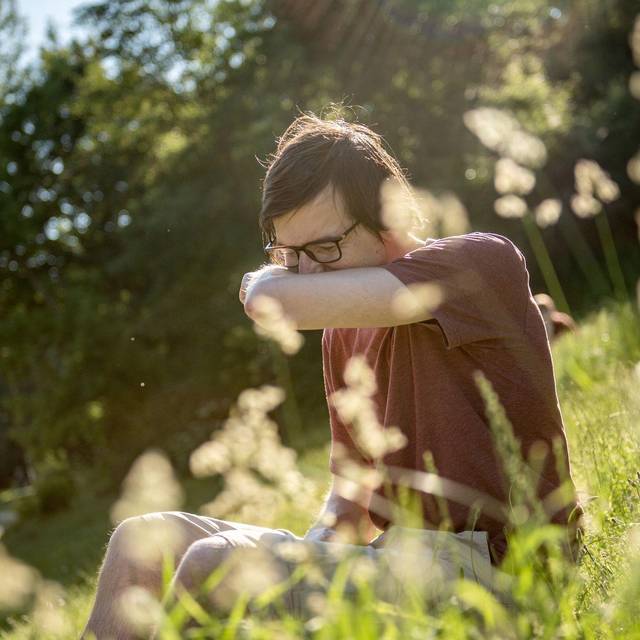 Mann in einem Park niest