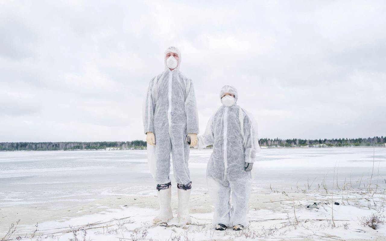 Ein Mann und ein Kind in Schutzanzügen halten Händchen