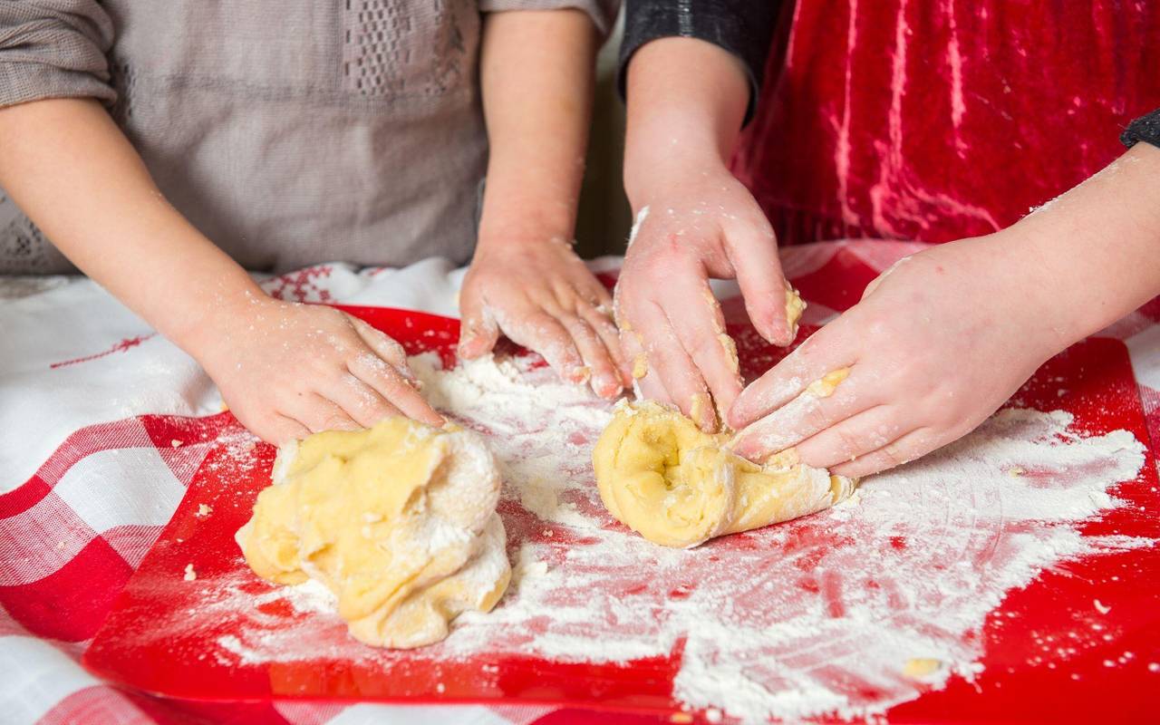 Zwei Mädchen kneten rohen Teig