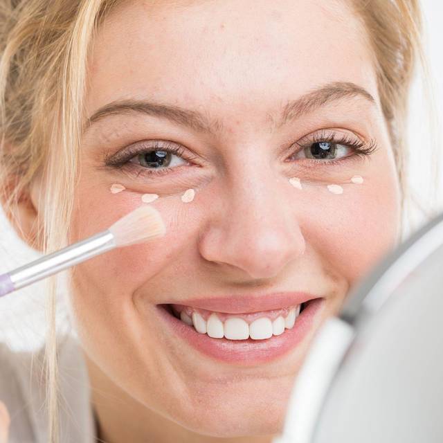 Eine Faru trägt Concealer auf