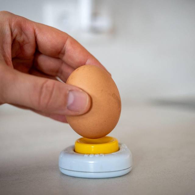 Ein Mann sticht ein Ei an