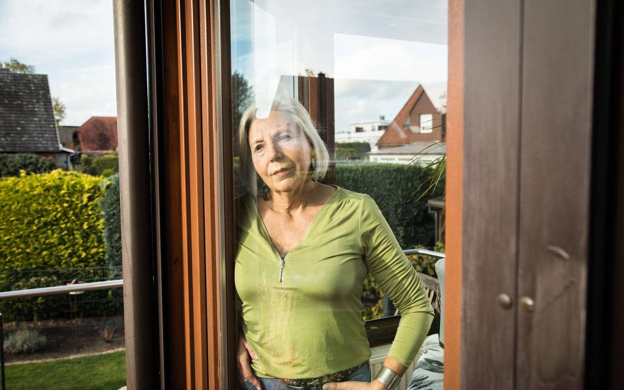 Eine Frau blickt aus einem Fenster auf einen Garten
