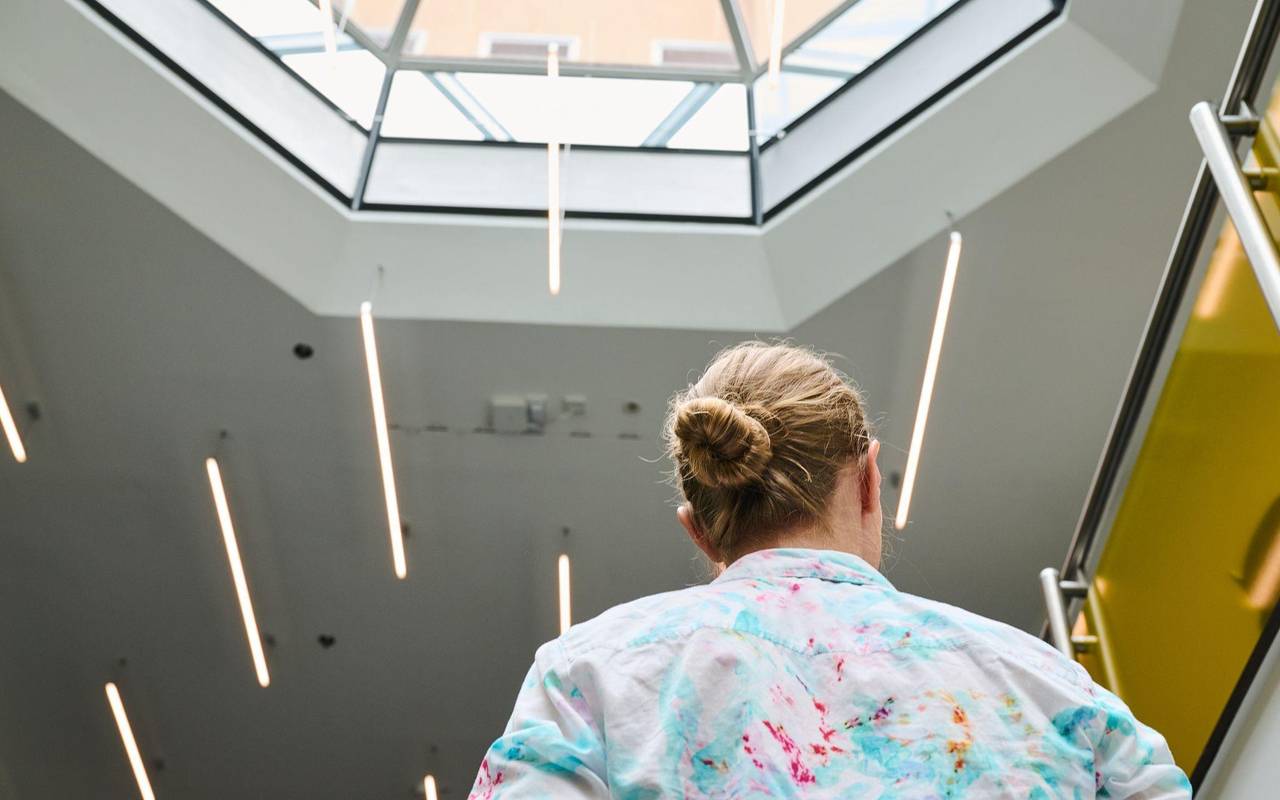 Eine Frau geht in einem Bürohaus eine Treppe hoch
