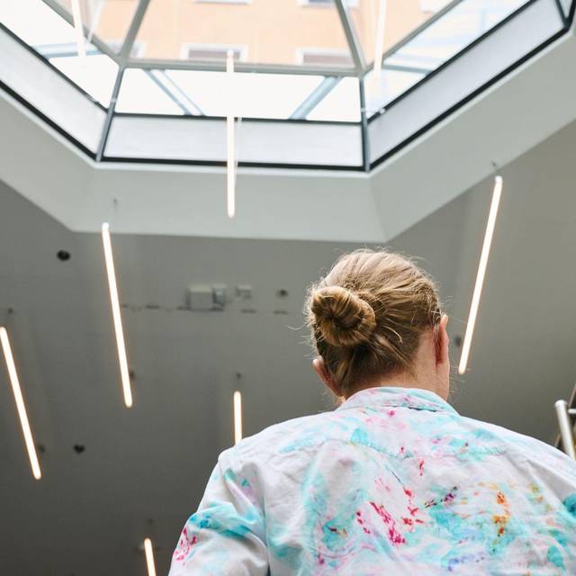Eine Frau geht in einem Bürohaus eine Treppe hoch