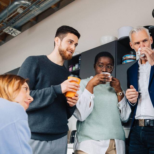 Eine Gruppe Kollegen verbringt ihre Pause in einer Büroküche