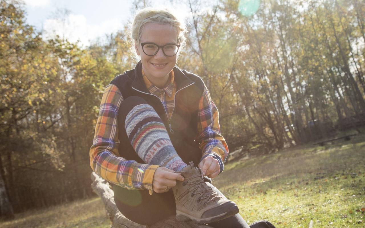 Eine Wanderin schnürt ihre Wanderstiefel