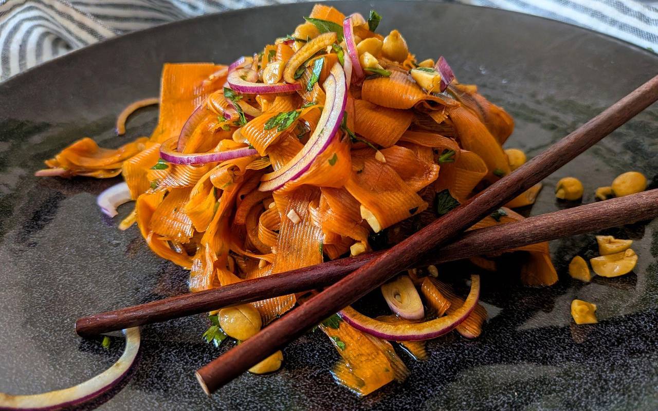 Ein Teller mit Karottensalat im Asia-Style steht auf dem Tisch