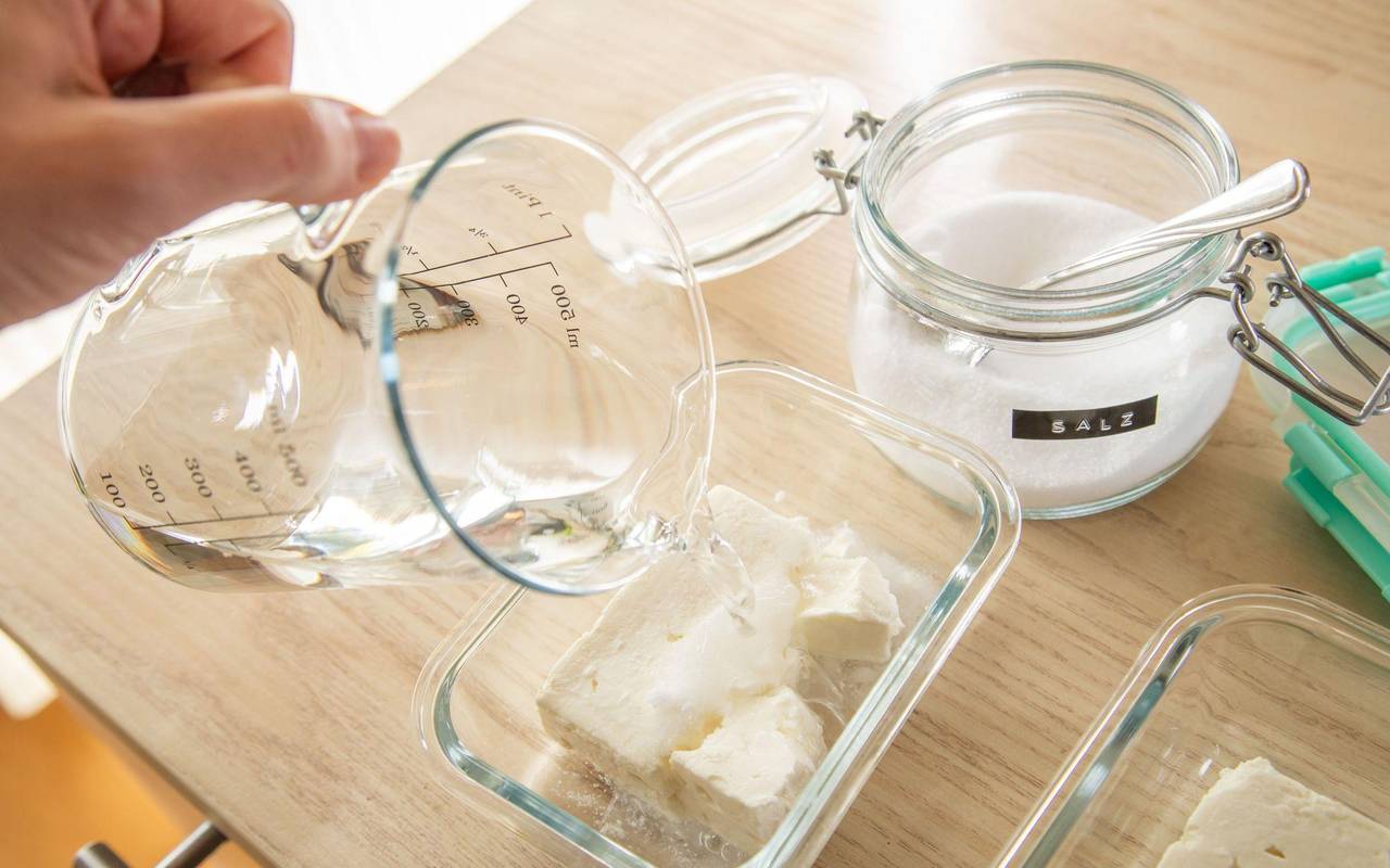 Wasser wird über einen Feta gegossen