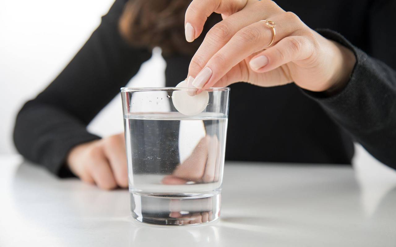 Brausetablette wird in ein Glas Wasser gegeben