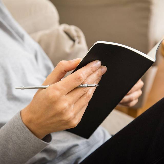 Eine Frau schreibt in ein Heft