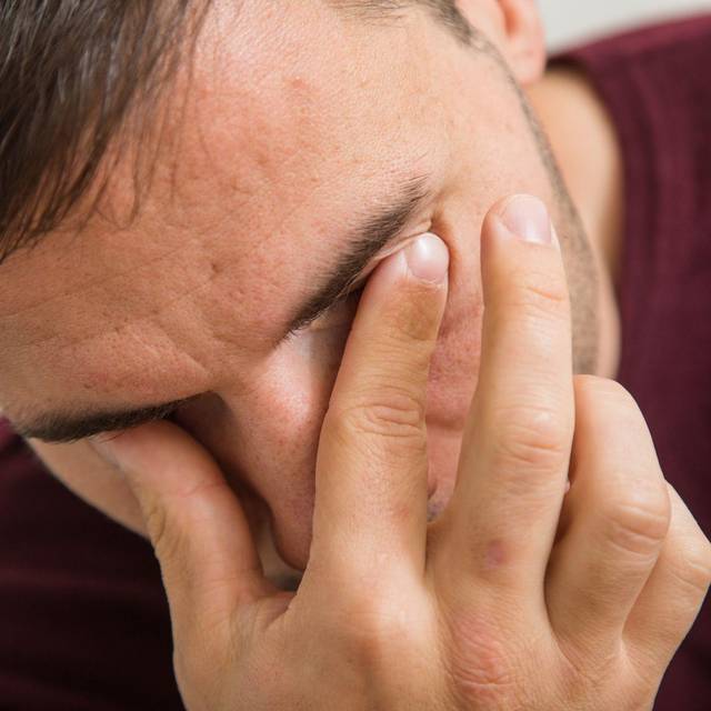 Mann fässt sich an die Augen