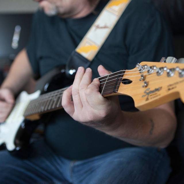 Mann spielt auf einer E-Gitarre