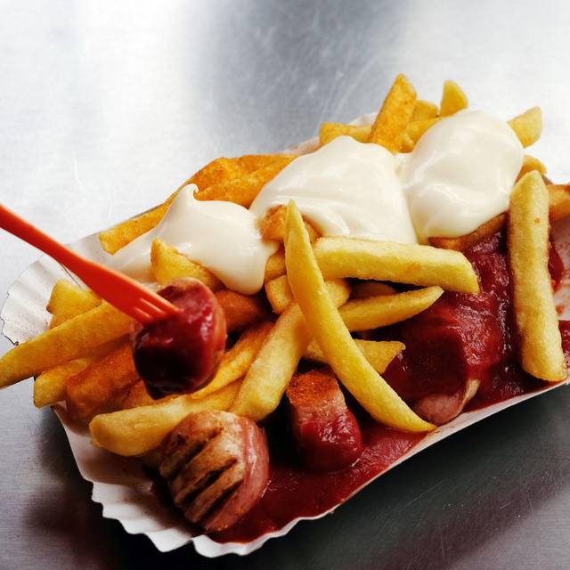 Eine Currywurst mit Pommes und Mayo