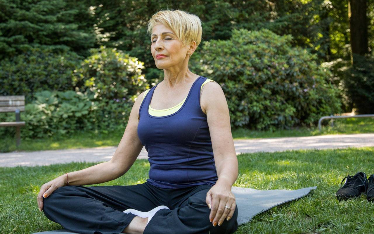 Frau macht Yoga-Übungen im Park