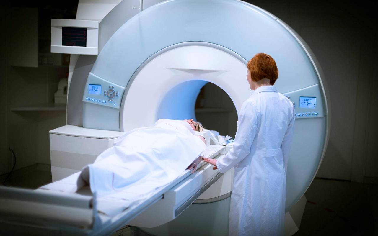 Ärztin bereitet eine Patientin für ein MRT vor