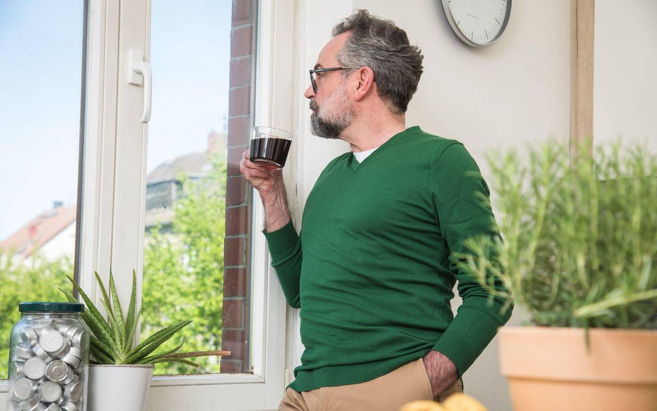 Mann trinkt Kaffee und schaut aus dem Fenster